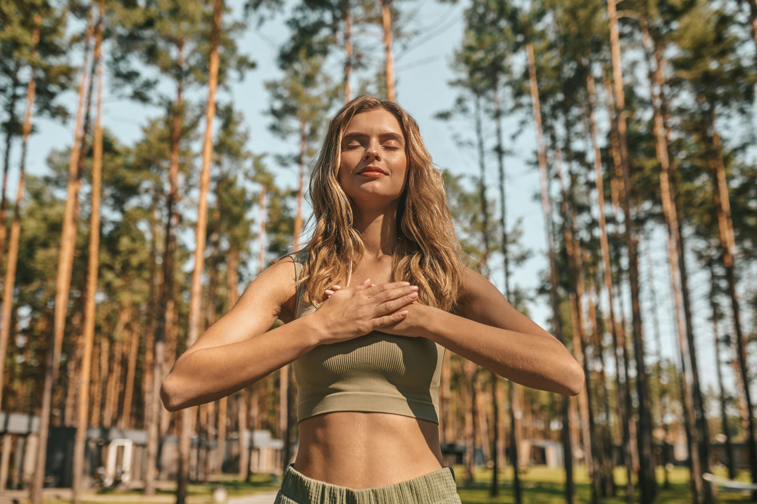 Cute blonde woman practising yoga outside and looking relaxed